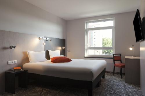 a bedroom with a large bed and a large window at The Originals Boutique, Hôtel d'Alsace, Strasbourg Sud (Qualys-Hotel) in Illkirch-Graffenstaden