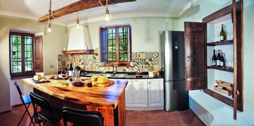 a kitchen with a wooden island in a kitchen with a refrigerator at Residenza il palazzo dal 1894 in Pugliano