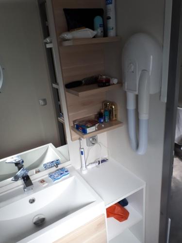 une salle de bain avec un lavabo blanc et un miroir dans l'établissement CAMPING LA PINEDE, aux Mathes