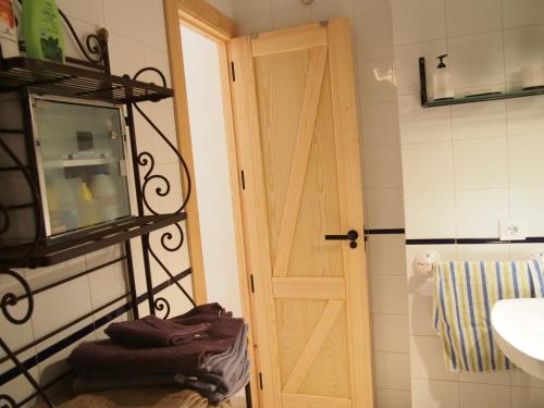 a bathroom with a wooden door and a sink at Apartamento Barbancho in Cáceres