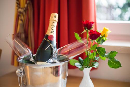 a bottle of champagne in a bucket on a table with flowers at Hotel Hubertus in Sankt Johann im Pongau