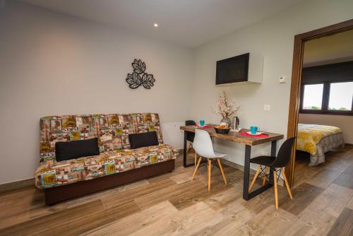 a room with a bed and a desk and a table at Apartamentos Casa Carin in Cadavedo