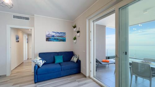 ein Wohnzimmer mit einem blauen Sofa und einer Glasschiebetür in der Unterkunft WePuglia - Dimora Adriatica in Monopoli