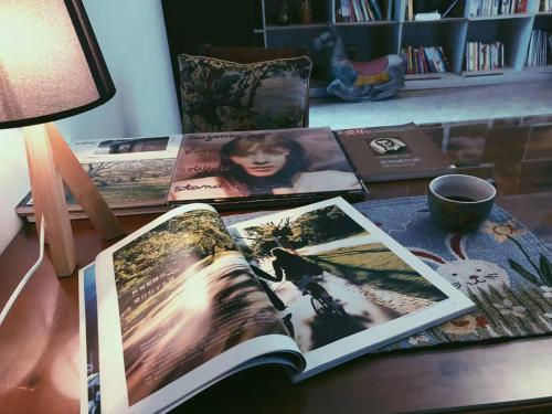 an open book on a table with pictures on it at Yuanyang Flower and Horse Inn in Yuanyang