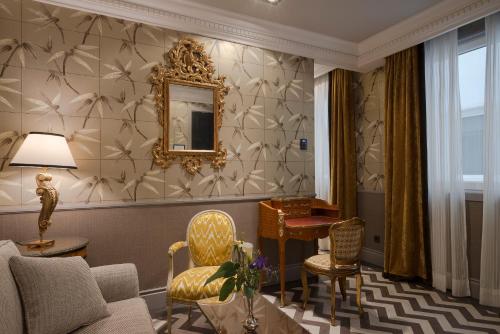 a living room with a couch and a mirror at Relais & Châteaux Heritage Hotel in Madrid