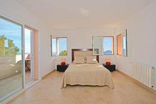 a white bedroom with a bed and a balcony at Villa Cactus in Inca