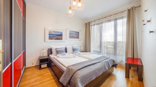 a bedroom with a bed and a large window at Olympic Park I, Sun & Snow in Kołobrzeg