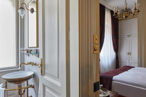 a bathroom with a bed and a sink in a room at Gerlóczy Boutique Hotel in Budapest