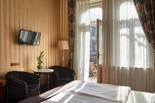 ブダペストにあるGerlóczy Boutique Hotelのベッドと窓のあるホテルの部屋