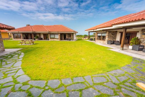 a large grassy yard with a bench in front of two buildings at Apartamentos Casa Carin in Cadavedo