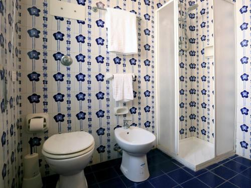 a blue and white bathroom with a toilet and a sink at Casa Barca - Le chiavi degli Iblei in Punta Braccetto