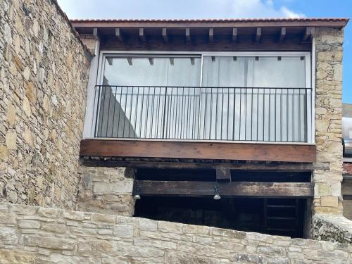 - un balcon dans un bâtiment en briques avec une fenêtre dans l'établissement Omodos Katoi Holiday Homes, à Omodos