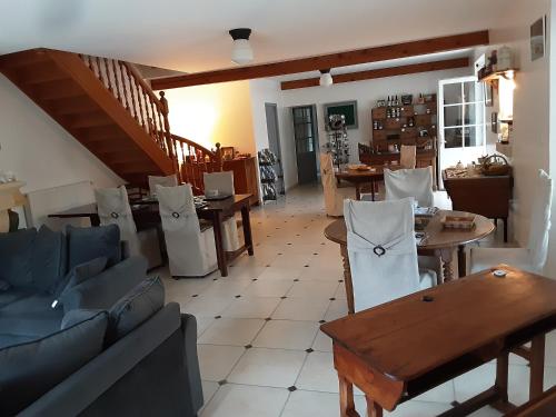a living room with couches and a table and chairs at Les Lavandières in Saint-Hilaire-la-Palud