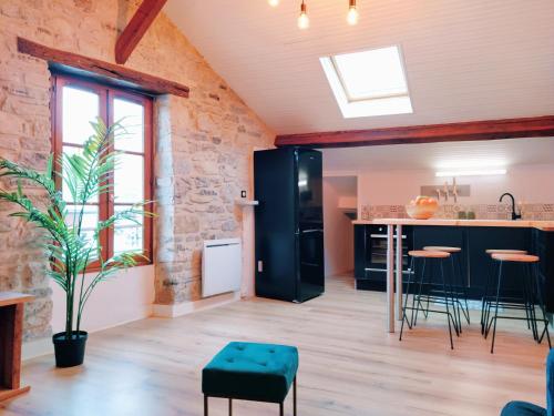 een keuken en een woonkamer met een stenen muur bij Le Chalet d'Amou in Bayonne