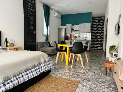 ein Schlafzimmer mit einem Bett und einem gelben Tisch mit Stühlen in der Unterkunft Appartamento Nuovissimo: La Casa Bolognese in Bologna