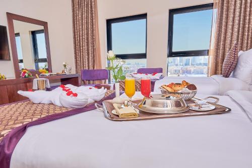 a breakfast tray on a bed in a hotel room at Carlton Dubai Creek Hotel in Dubai
