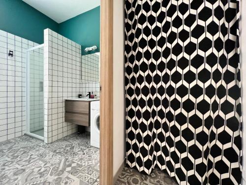ein Bad mit einem schwarz-weiß gemusterten Duschvorhang in der Unterkunft Appartamento Nuovissimo: La Casa Bolognese in Bologna