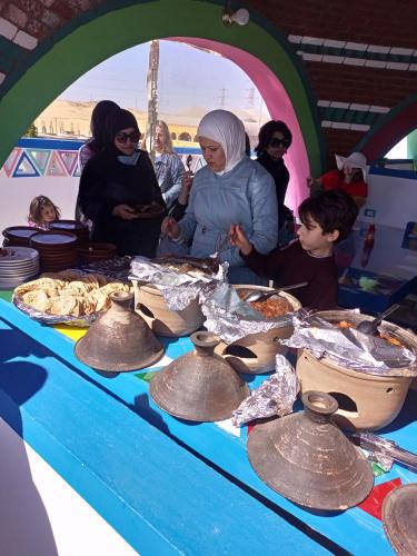 a group of people standing around a table with bells at malindy KA ماليندى كا in Aswan