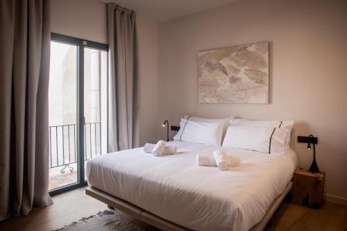 Schlafzimmer mit einem großen weißen Bett und einem Fenster in der Unterkunft NC APARTMENTS RAMBLA3 in Figueres