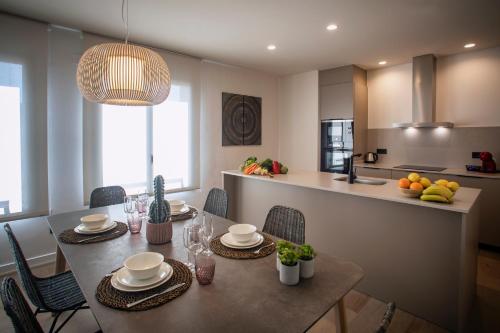 a kitchen with a table with chairs and a dining room at NC APARTMENTS RAMBLA3 in Figueres