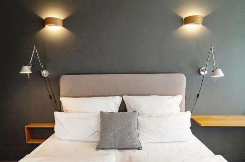 a bedroom with a bed with three lights above it at MY PLACE Hotel in Hamburg