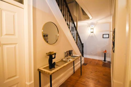 a hallway with a staircase with a mirror and a counter at Charme 19 in Coimbra