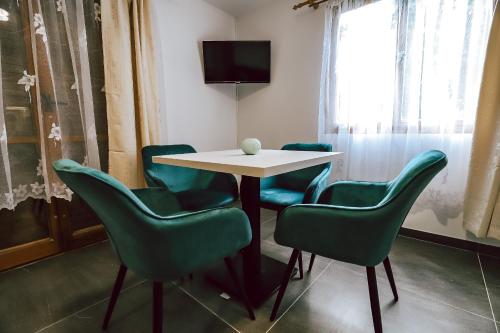 a room with a table and chairs and a television at Chaty a Apartmány Hracholusky Kemp Kosatka in Pňovany