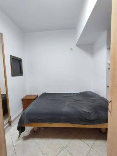 a bedroom with a bed with a black blanket at Квартира в непосредственной близости от моря и пляжа в Хайфе /Apartment near the sea and the beach in Haifa in Haifa