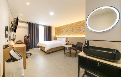 a hotel room with a bed and a mirror at LABE Hotel in Jeonju