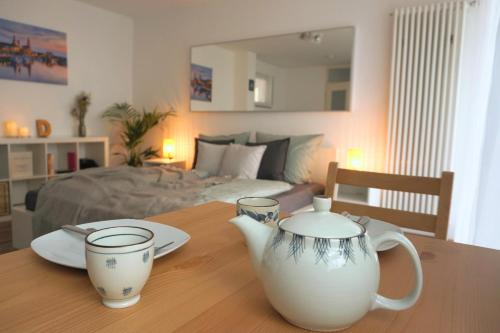 einen Tisch mit zwei weißen Vasen auf einem Tisch mit einem Bett in der Unterkunft Gemütliche Ferienwohnung in ruhiger Lage in Dresden