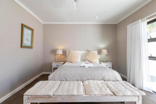 a bedroom with a large bed with two tables and a window at Fish Eagle Manor in East London