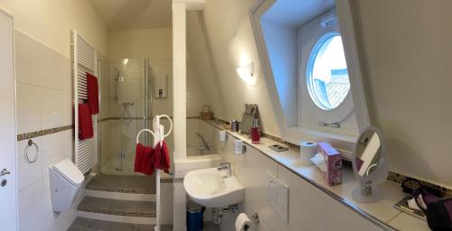 ein weißes Badezimmer mit Waschbecken und Dusche in der Unterkunft Villa Sturm Rüdesheim am Rhein in Rüdesheim am Rhein
