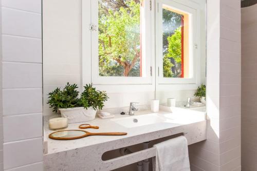 biała łazienka z umywalką i oknem w obiekcie Preciosa Casa Ca Madò Maria con vistas a Bunyola w mieście Bunyola