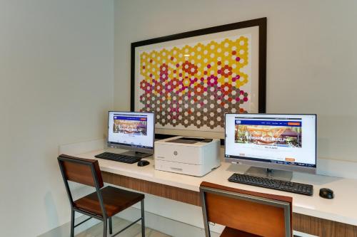 a desk with two computers and a printer on it at Holiday Inn Express - Cincinnati North - Monroe by IHG in Monroe