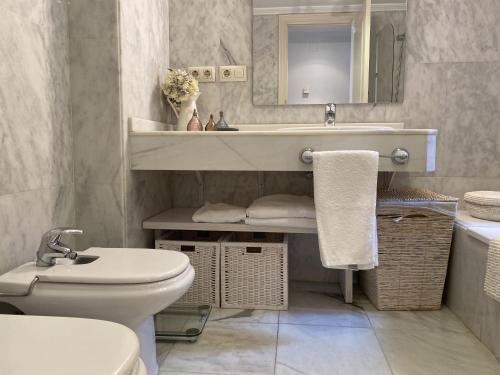 une salle de bain avec un lavabo, des toilettes et un miroir dans l'établissement Córdoba Cool Vailima 2, à Cordoue