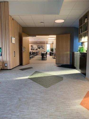a hallway of a office with tables and chairs at Hotell Lassalyckan in Ulricehamn