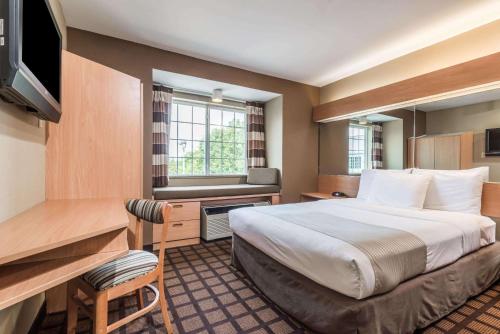 a hotel room with a bed and a desk at Microtel Inn & Suites by Wyndham West Chester in West Chester