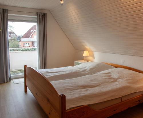sypialnia z dużym łóżkiem i oknem w obiekcie Ferienwohnung Grashof w mieście Rettin