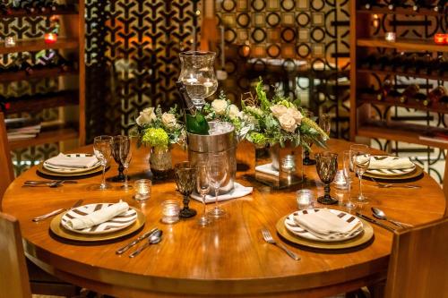 a wooden table with plates and wine glasses on it at Hyatt Regency Villahermosa in Villahermosa