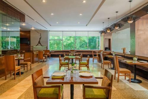 a restaurant with wooden tables and chairs and large windows at Hyatt Regency Villahermosa in Villahermosa