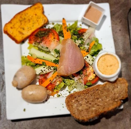 a plate of food with meat and vegetables and bread at LE MANGUIER in Baie-Mahault
