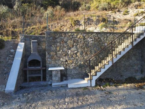 a stone wall with a staircase and a stone oven at Rifugio del Granasco in Stella