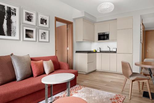 a living room with a red couch and a table at Holiday Inn & Suites - Dubai Festival City by IHG in Dubai