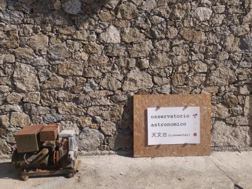 a stone wall with a sign next to a box at Rifugio del Granasco in Stella