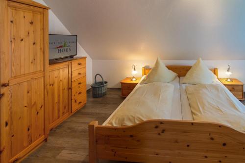 1 dormitorio con 1 cama de madera y 2 almohadas en Küstenkoje, en Nessmersiel