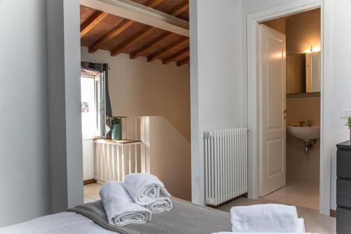 a bedroom with a bed with towels on it at Coco Places Apartments Santa Maria Novella, Centro Storico in Florence