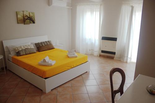 a bedroom with a bed with a yellow bedspread at Casa Graziella - la casetta in Portacomaro