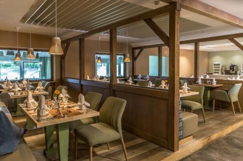 a restaurant with tables and chairs and a bar at Das Aunhamer Suite & Spa Hotel in Bad Griesbach
