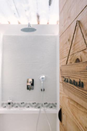 a bathroom with a shower and a wooden wall at miCielo - Baumhäuser in Vejer de la Frontera