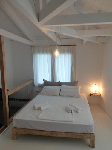 a bedroom with a bed with two towels on it at Villa Rena Agios Petros in Áyios Pétros